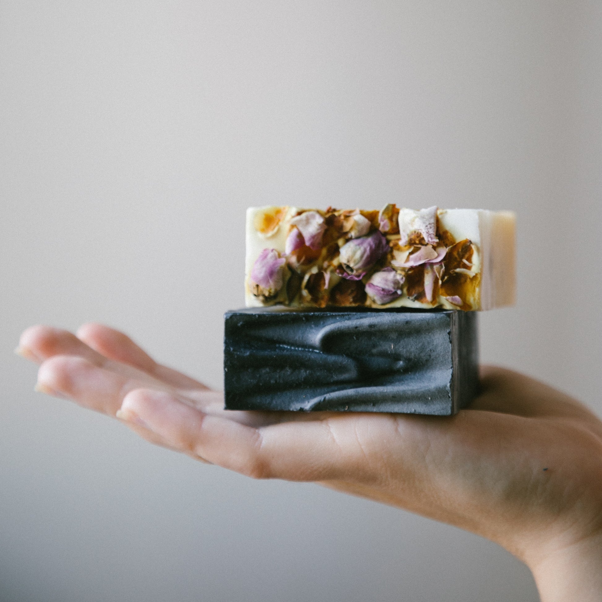 deux barres de savon naturel et artisanal dans une main